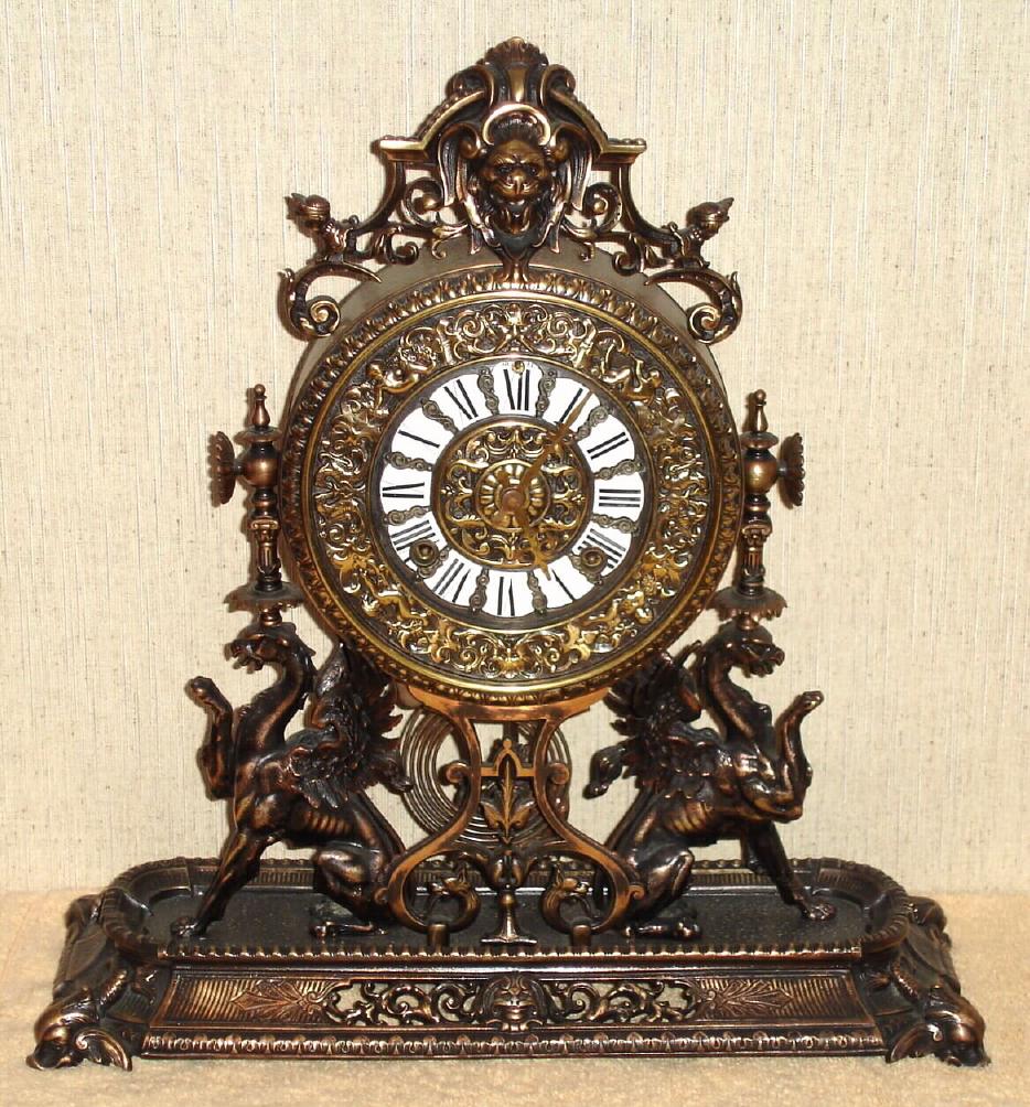 Ansonia Clock Co., New York, C.1886 "RENAISSANCE", cast metal mantel clock in Antique Brass finish, 8-day premium embossed movement and special cast pendulum bob with 2 cherubs flanking the Ansonia logo. — Antique Clocks Price Guide