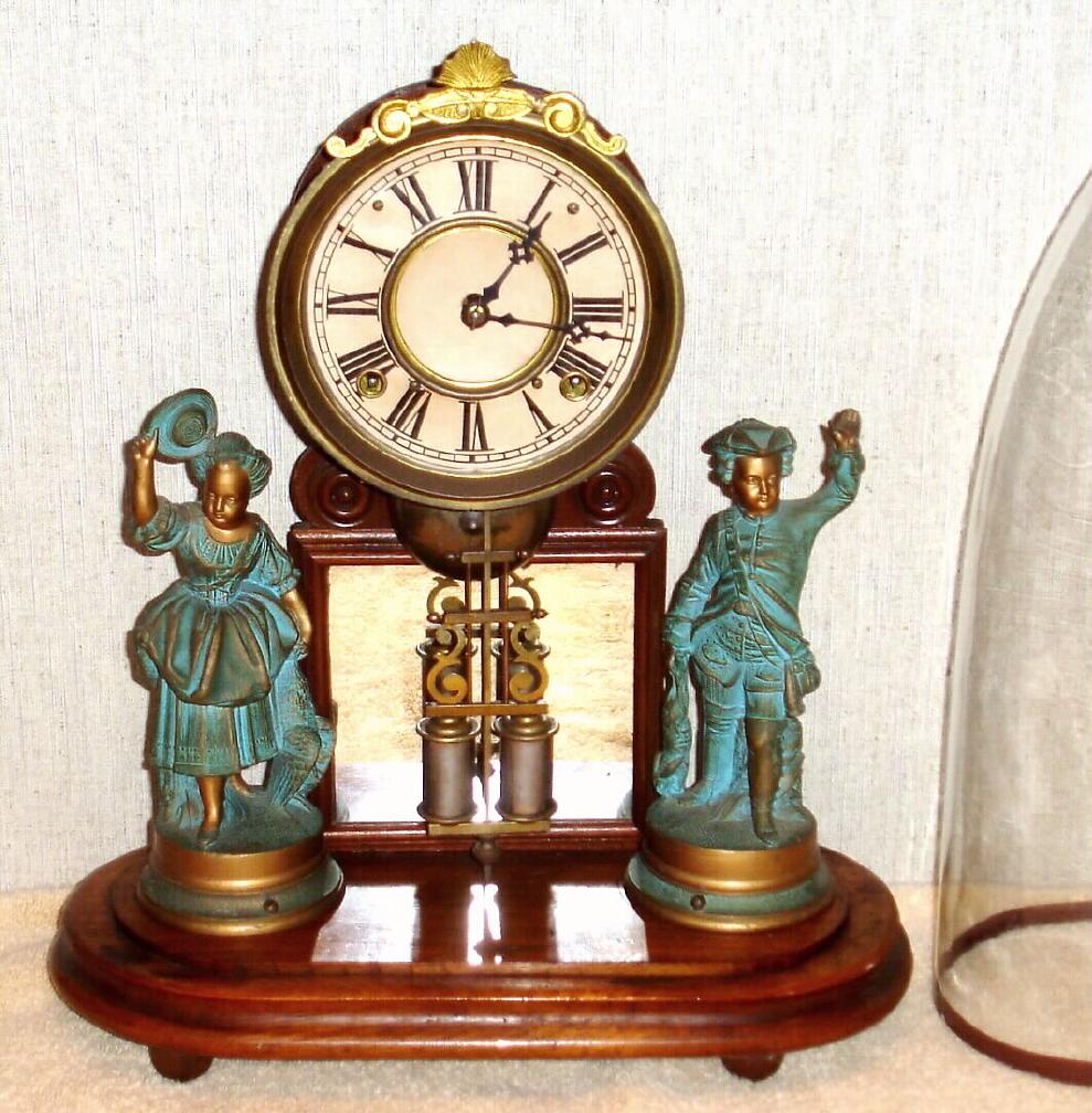 H. J. Davies, New York, "CRYSTAL PALACE" C.1875, with original glass dome. 8-day bell strike movement, mounted to a walnut base, with a pair of statues, the barrel pendulum swinging in front of a framed mirror. — Antique Clocks Price Guide