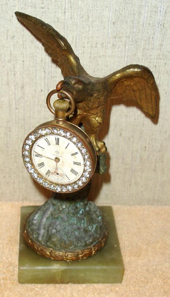 Ansonia Clock Co., New York, C.1900, "EAGLE" cast metal desk novelty, with 1-day watch size clock with brilliant studded bezel hanging from his beak. — Antique Clocks Price Guide