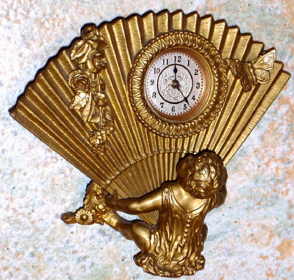 Ansonia Clock Co., New York, C.1900, "BABY" cast metal desk "fan" being held by an infant, with a 1-day timepiece movement. — Antique Clocks Price Guide