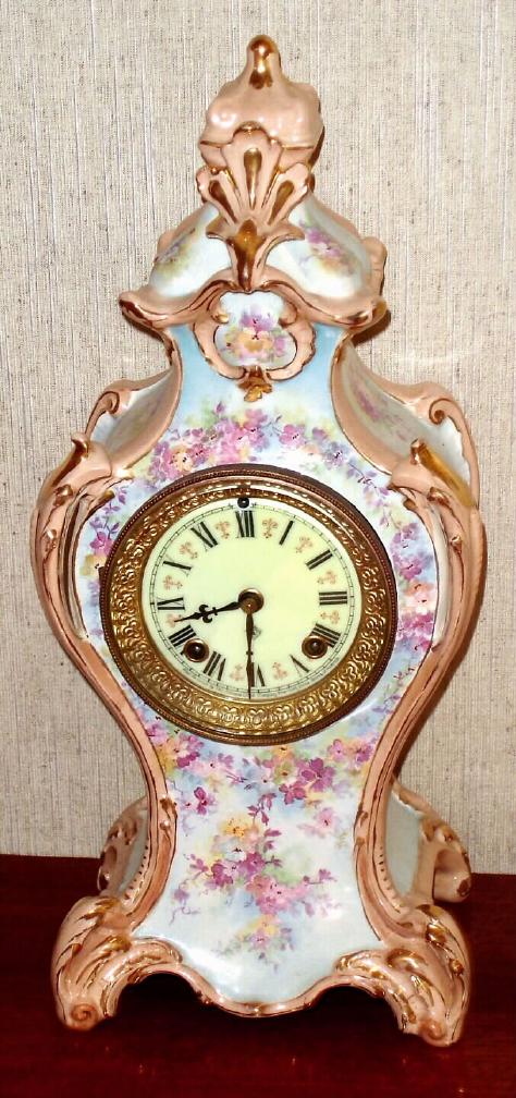 Ansonia Clock Co., Royal Bonn, "LA ROCHELLE", porcelain china clock, with one piece porcelain dial, edges are beige and fields are sky blue, with yellow and violet floral decorations. — Antique Clocks Price Guide