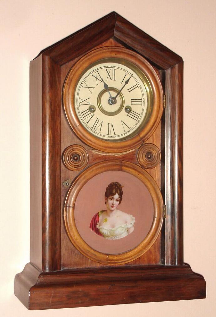 E. Ingraham, Bristol Conn. "DORIC No. 2" mantel clock 30 hour time and strike spring driven mvt in mahogany and rosewood veneered case with RN painted gilt pan dial and a tablet featuring a lovely decal transfered portrait of a striking young lady, c1874 — Antique Clocks Price Guide