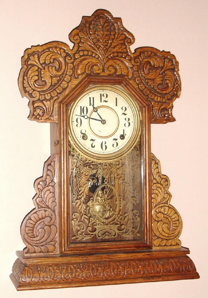 E. Ingraham Co., Bristol Conn. "CAYUGA" model gingerbread clock from Ingraham's Lake Line seried 8 day time and half hour strike spring driven mvt in oak case with Arabic numeral gilt pan 6" dial, c1915 — Antique Clocks Price Guide