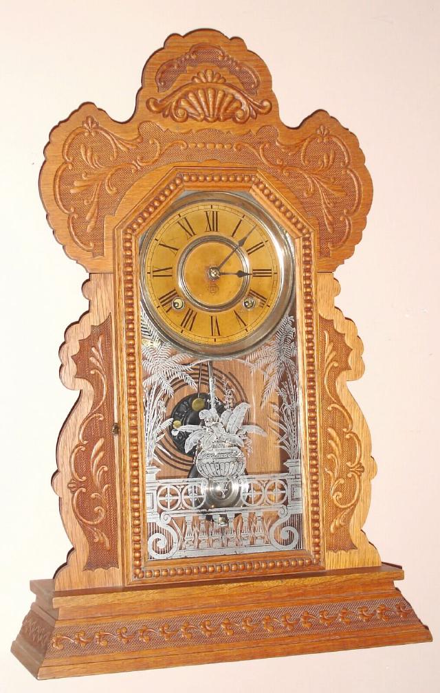 Ansonia Clock Co., NY. "LINDELL" model from Ansonia's "L" Assortment series with 8 day time and half hour strike spring driven mvt in carved oak case with nickel plated 6" dial pan, c1901 — Antique Clocks Price Guide
