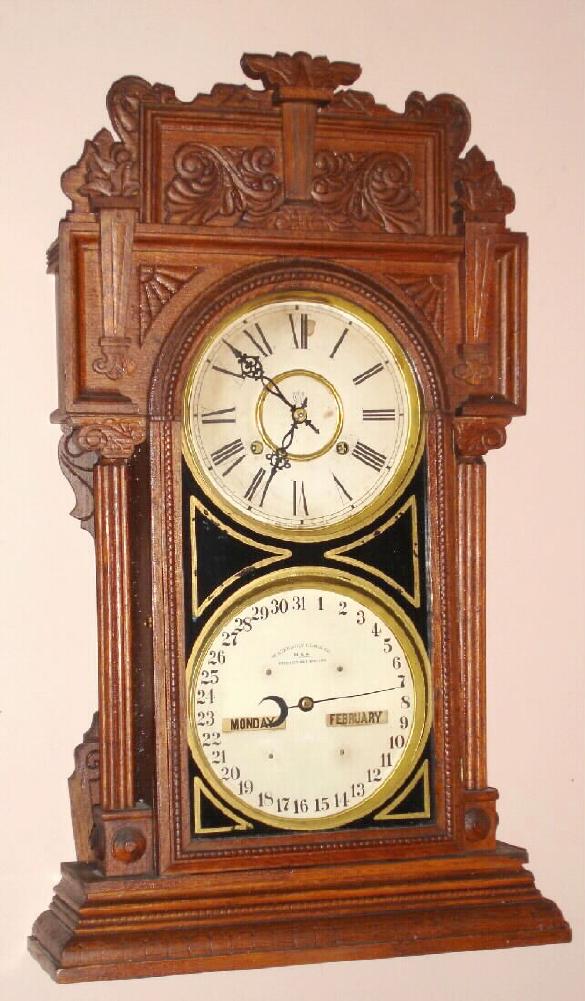 Waterbury Clock Co., Waterbury, Conn. "CALENDAR NO. 43" double dial perpetual calendar with 8 day time and strike spring driven mvt in walnut case with two 8" gilt pan dials, c1912 — Antique Clocks Price Guide