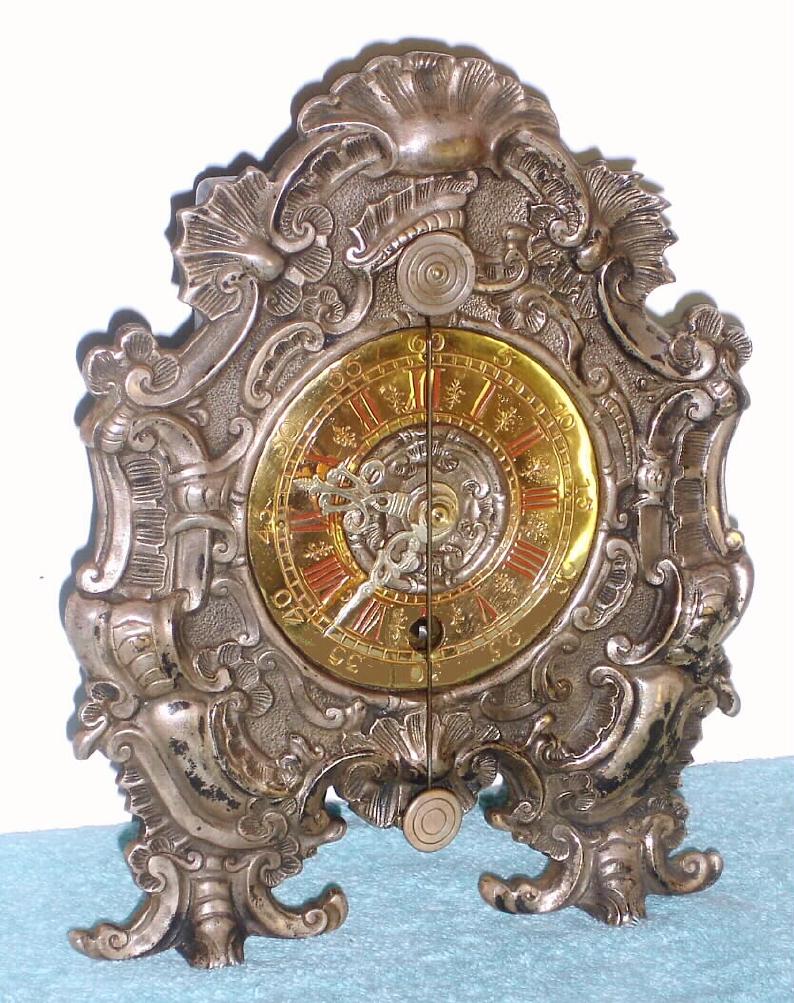 German, reproduction Teller-Uhr, mantle style, in a heavy cast brass case, cast brass dial and cast hands, cow's tail pendulum, c.1975. This is a quality clock; they sold new for a thousand D-marks, around $300 at the time. — Antique Clocks Price Guide