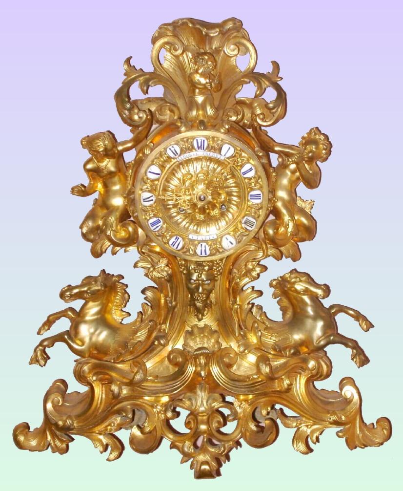 French, Lerolle Freres, a'Paris, (blinker) dore bonze clock in the rococo fantasy style with a brace of hippocampi with webbed feet emerging from the waves, on left a young Amphitrite with fish tails and to her right a cherub with 2 fish fins in lieu of feet, playing a conch, and at the top a small cherub with two sticks in his hands for percussion accompaniment. Just below the dial a bust of Neptune [or Poseidon in Greek], with animated eyes that move back and forth with each tick. C.1850. — Antique Clocks Price Guide