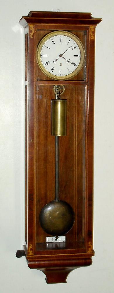 A repro miniature Vienna timepiece in the early Biedermeier style, the case of crotch mahogany with holly banding around the edges and additional inlay. The weight driven movement is a well made copy of a mini original. C.2000, — Antique Clocks Price Guide