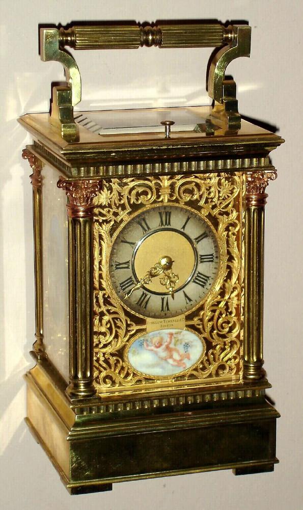Carriage clock retailed by Bigelow Kennard and Co., Boston with hour repeat and half hour strike 8 day platform lever escapement spring driven movement in Anglais Riche case with two tone Corinthian columns surmounted by rose gold colored fancy capitals with Roman numeral silvered chapter ring surrounded by pierced gilt mask and set on three sides with ivory painted panels of cherub scenes, c1900 — Antique Clocks Price Guide