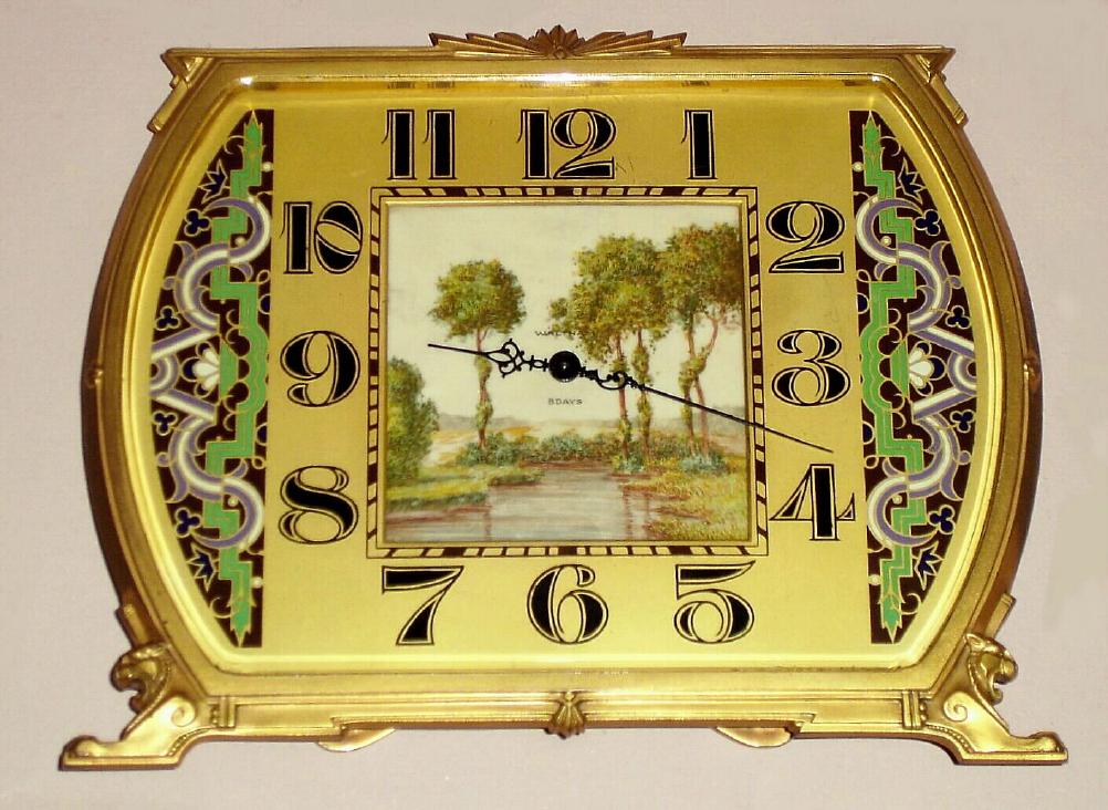 German desk clock with 8 day spring driven Swiss movement in Art Deco gilt case with center inset painted ivory panel on dial with pastoral scene and geometric enameled decoration bordering Arabic numerals, c1925 — Antique Clocks Price Guide