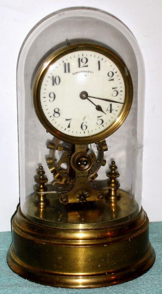 Eureka Clock Co Ltd, London battery powered, electro-magnetic timepiece mounted on brass base under dome with exposed rotating balance, serial No. 7183 c1910 — Antique Clocks Price Guide