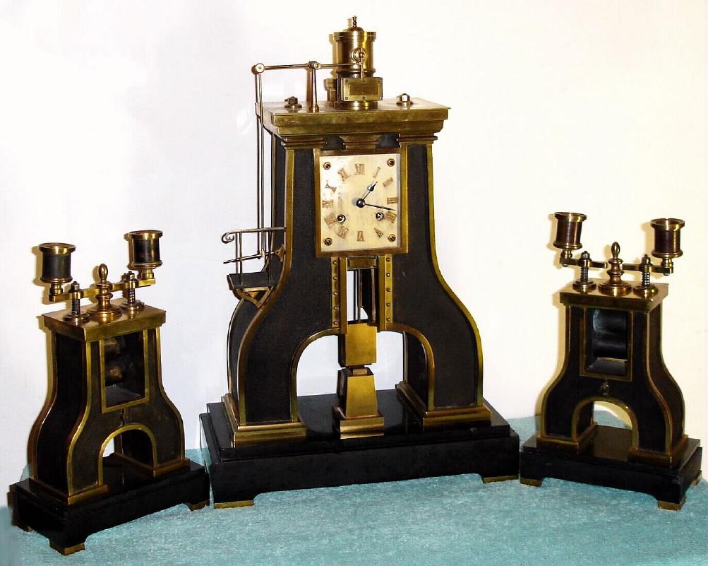 French "STEAM HAMMER" mantel clock from the Industrial series designed by Guilmet, 8-day time and bell strike spring driven movement with applied Roman numeral gilt metal dial, the vertical impact "hammer" serving as the pendulum after the power has been transferred 9 times, sNo. 759, C.1880 including matching steam roller candelabra on black marble base — Antique Clocks Price Guide