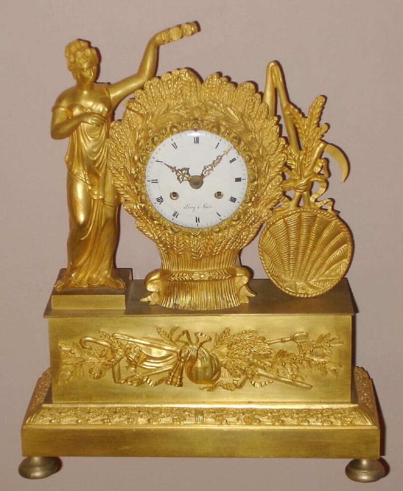 French, Leroy a'Paris, C.1840, Ormolu figural clock depicting the goddess of Harvest placing a crown on a bushel of wheat, with a grain basket standing on the right side. With a bell strike movement with silk thread suspension. — Antique Clocks Price Guide
