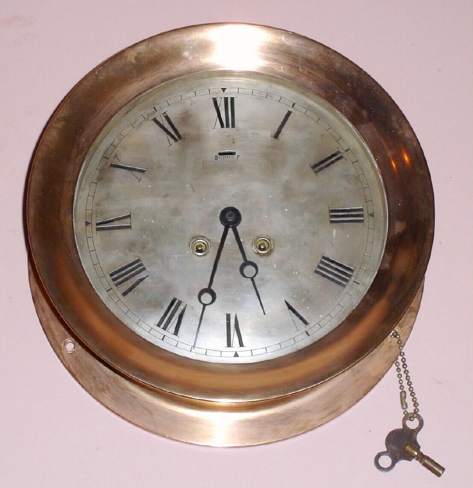 Chelsea Clock Co., Circa 1903, 8-day time and ship's bell strike CHELSEA model wall clock, serial no. 7209, 8.5" dial, red brass case with hinged bezel with button latch. — Antique Clocks Price Guide