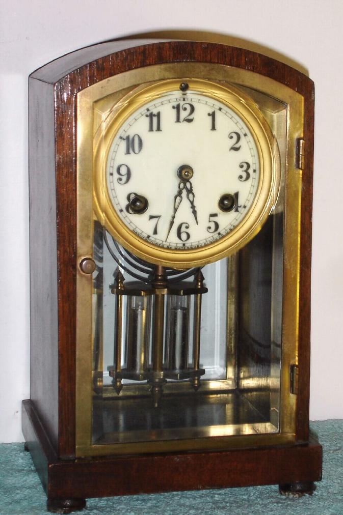 Waterbury Clock Co., C.1914, "TROUVILLE", mahogany cased 'crystal regulator', with 2-vial pendulum and porcelaian dial. — Antique Clocks Price Guide