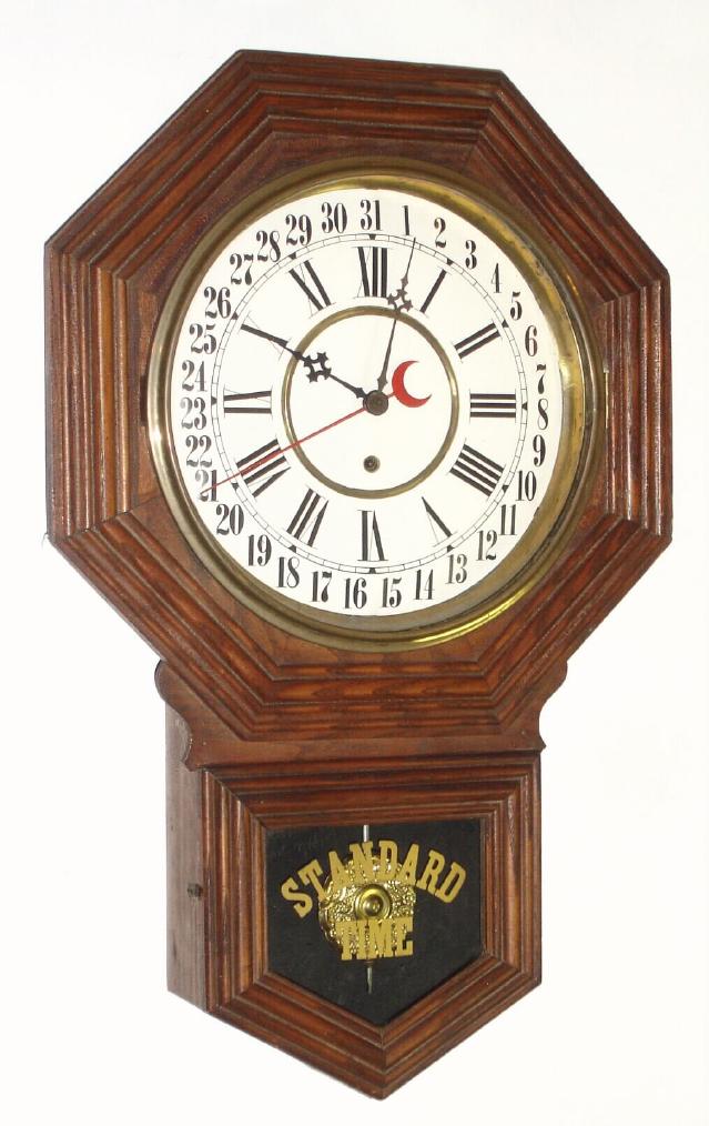 Wm. L. Gilbert Clock Co., 12" Octagon Drop, model No. 3027, timepiece with calendar, in oak. This model wtih simpler molding replaced the Admiral model around 1915. 8-day duration. — Antique Clocks Price Guide