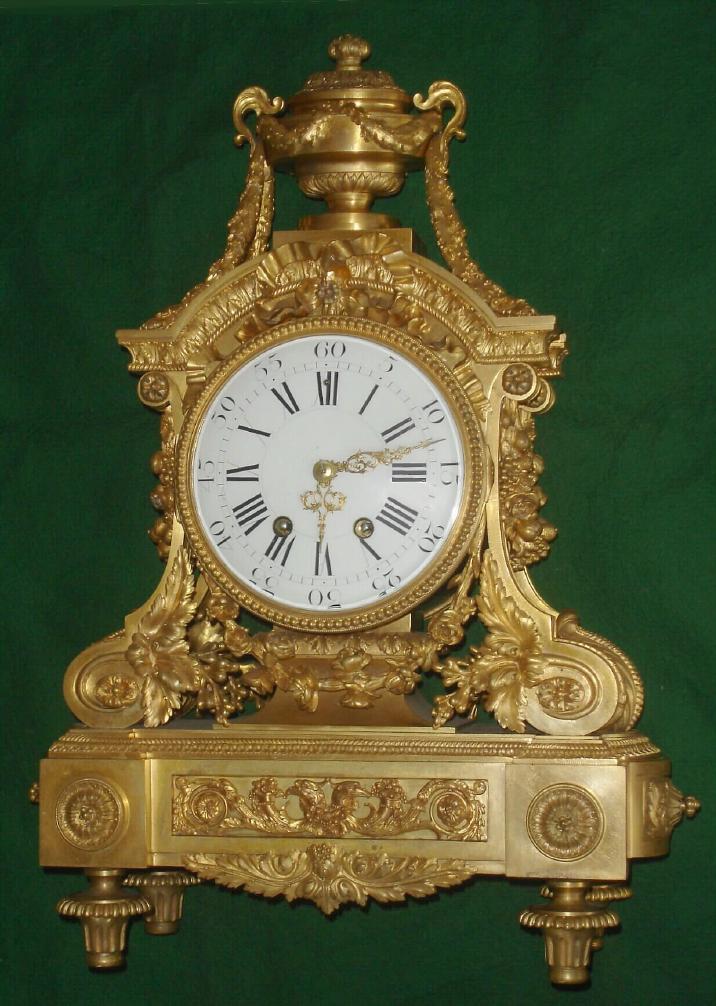 French, Dufaud, Paris, case possibly by Link, C.1890, in the Louis XV style of the previous century, and of the highest quality. There are profuse floral decorations, fruit swags to the sides and acanthus swags drape the top urn w/finial. Large cast and fluted feet support the base. — Antique Clocks Price Guide