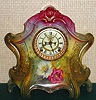 Ansonia Clock Co., C.1910, Royal Bonn, "LA LAYON" porcelain china cased clock, with 8-day, gong strike mov't with open escapement on porcelain dial, in a multi-colored case, red top, yellow center + dark green at base, with two large peonies below the dial, red and white.