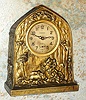 Ansonia Clock Co., cast pot metal BANK novelty, the case depicting dogs and horseback hunters capturing a wild boar, and the back with slots for coins and a key lock door to remove the money [no key], c.1910