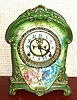 Ansonia Clock Co., C.1914, Royal Bonn, "LA CRUZ" porcelain china cased clock, with 8-day, gong strike mov't with open escapement on porcelain dial, in a medium green case with multi colored flowers to the case front and sides.