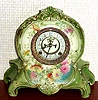 Ansonia Clock Co., C.1905, Royal Bonn, "LA RIVIERE" porcelain china cased clock, with 8-day, gong strike mov't with open escapement on porcelain dial, in a light green case with multi colored floral decorations.