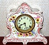 Ansonia Clock Co., C.1905, Royal Bonn, "LA LORNE" porcelain china cased clock, with 8-day, gong strike mov't with one piece porcelain dial, in a white china case with pink-beige accents and gold highlights, the case decorated with mostly yellow flowers.