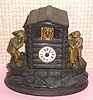 German, (Meyer?), Novelty Chalet Automaton, C.1875. Note the dog in center of log cabin has a panting tongue, and the man at the left has his head bobbing back and forth as he tries to see what is going on. Two lovers at right in romantic embrace. Like other clock in this series, this one utilizes a small, pendulette movement, with the dog's tongue and gents head attached by a wire to the verge.