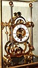 Chinese, Skeleton clock, after the style of Harrison, with a grass hopper escapement, single fusee timepiece, in a glazed case w/ brass edges, front door for winding, and a drawer in the base to hold the key.