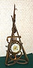 Ansonia Clock Co. New York, C.1900, "NAVY", 1-day novelty clock, consisting of a clock in an anchor, hung from block and tackle, suspended from the top of tow oars and a grappling hook, the whole with a trefoil of rope as a base.