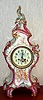French, Japy Freres, ROYAL BONN, porcelain china, LE GRANDE, in attractive shades of magenta with gold highlights and 3 cherubic children on the front panel, shown playing, one with book, another with lyre. The porcelain dial also with fine decorations.