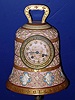 French, for Tiffany, Circa 1900, 8-day time and gong strike porcelain clock in the form of a church bell retailed by Tiffany and Co., NY. This is a porcelain version of the bronze "Pater Noster" clock that we have sold in the past {there is also a mini brass in tomorrow's session}. Has a fancy trademark of the porcelain company inside the case. The circumference has 8 angels in relief, each playing a different musical instrument.
