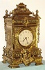 European, a very large Victorian cast brass table clock, with an equally large double chain fusee movement with heavy solid plates. Strikes the hours on a very large coiled wire cathedral gong. The case is profusely decorated with leaves and swags, a winged cherub below the 7" silvered dial with Arabic numerals, + surmounted by 4 pineapple finials and giant double acanthus swags with ribbon binding, c.1880.