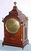 European, for Camerden and Forster, NY, classic English Regency styled bracket clock, 3-train, Westminster chime on 4 enormous coiled flat wire gongs, in a mahogany case with reeded quarter columns, brass capitals and stop fluting, C.1900 {in the style of 80 years earlier}. Strikes the hours on an even larger coiled gong.