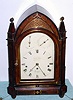 English, John Fleet, 6-tune musical bracket clock, in a Gothic styled mahogany case with brass inlay, and a painted dial with subsidiary rings in the arch for Chime-Not Chime, and the right ring with the tunes: God Save the King, Del Caros Fancy, Russian Dance, Bonny Lad, White Cockade and Miss Barker's Hornpipe, playing on a nest of 12 bells with 13 hammers, the 3-train mov't with chain fusees and engraved back plate, C.1820