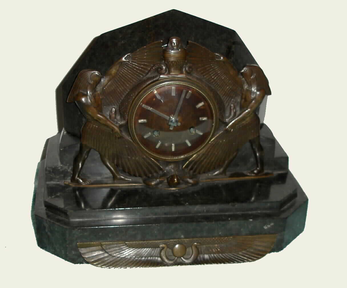 Art Nouveau French marble and bronze table clock 8 day time and half hour mov't strikes on bell, in Egyptian motif marble case with bronzed dial and silvered baton hands and hour markers flanked by bronze serpents and figures of Ra and supported by a tortoise, c1915 — Antique Clocks Price Guide