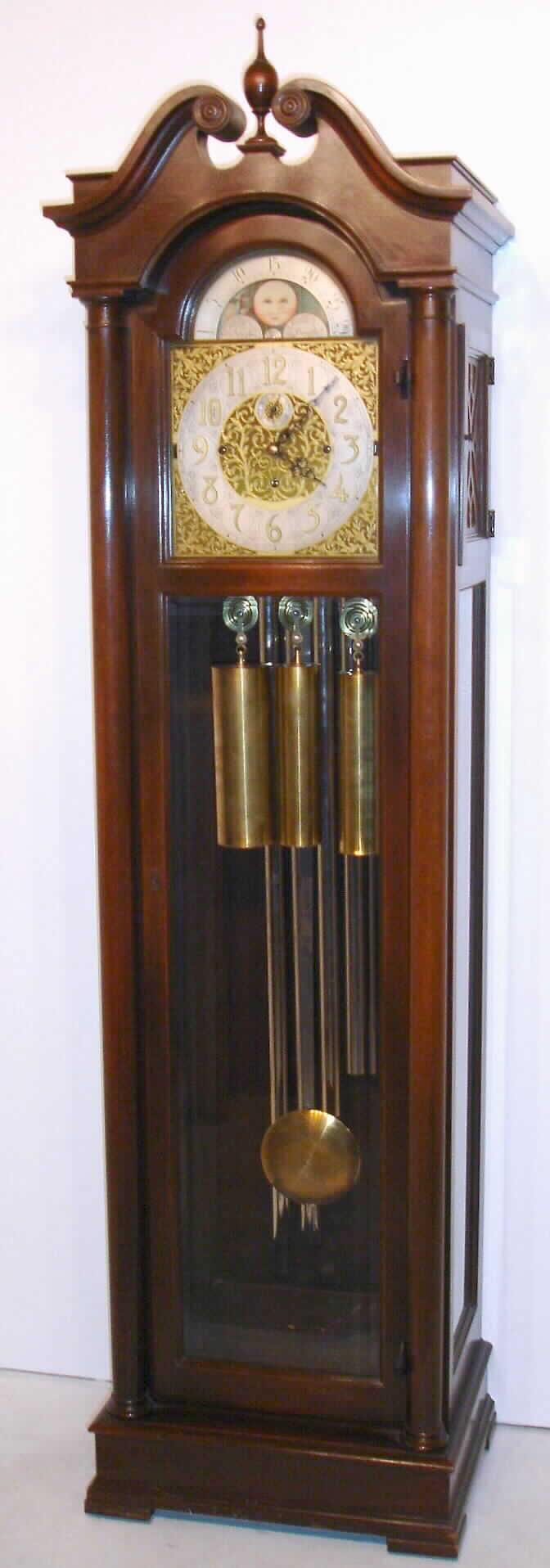 Winterhalder and Hofmeier, Neustadt, Baden, Germany, tall clock, retailed/ cased by Colonial Manufacturing Co., Zeeland, Mich. (signed on movement and on plaque inside of door) 8 day, 3-wt, quarter chime, Westminster tune on 5 tubes movement in Honduras mahogany case with brass rolling moon phase dial with strike and chime silent levers and signed "W. and H., Sch.", c1920 — Antique Clocks Price Guide