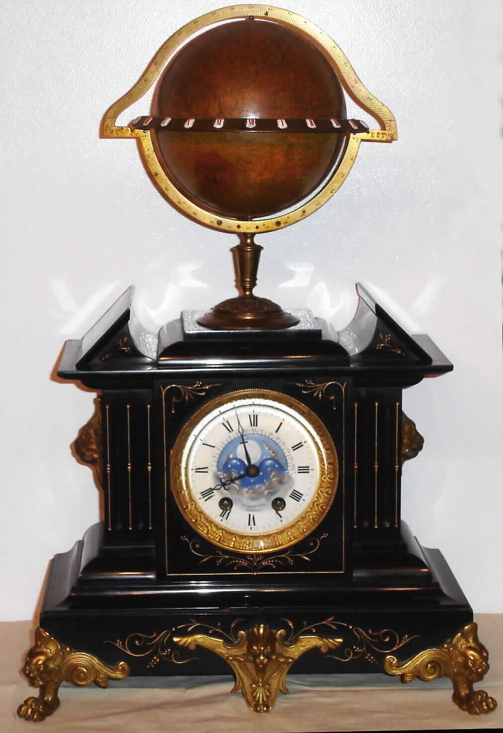 Edouard Serin, Paris, Globe Clock world time, a 5.5" globe with a brass equator ring showing 24 hours, 1-12 in red and 1-12 again in black, and with a rotating Halifax moon dial and scale showing the age of the moon in days. — Antique Clocks Price Guide