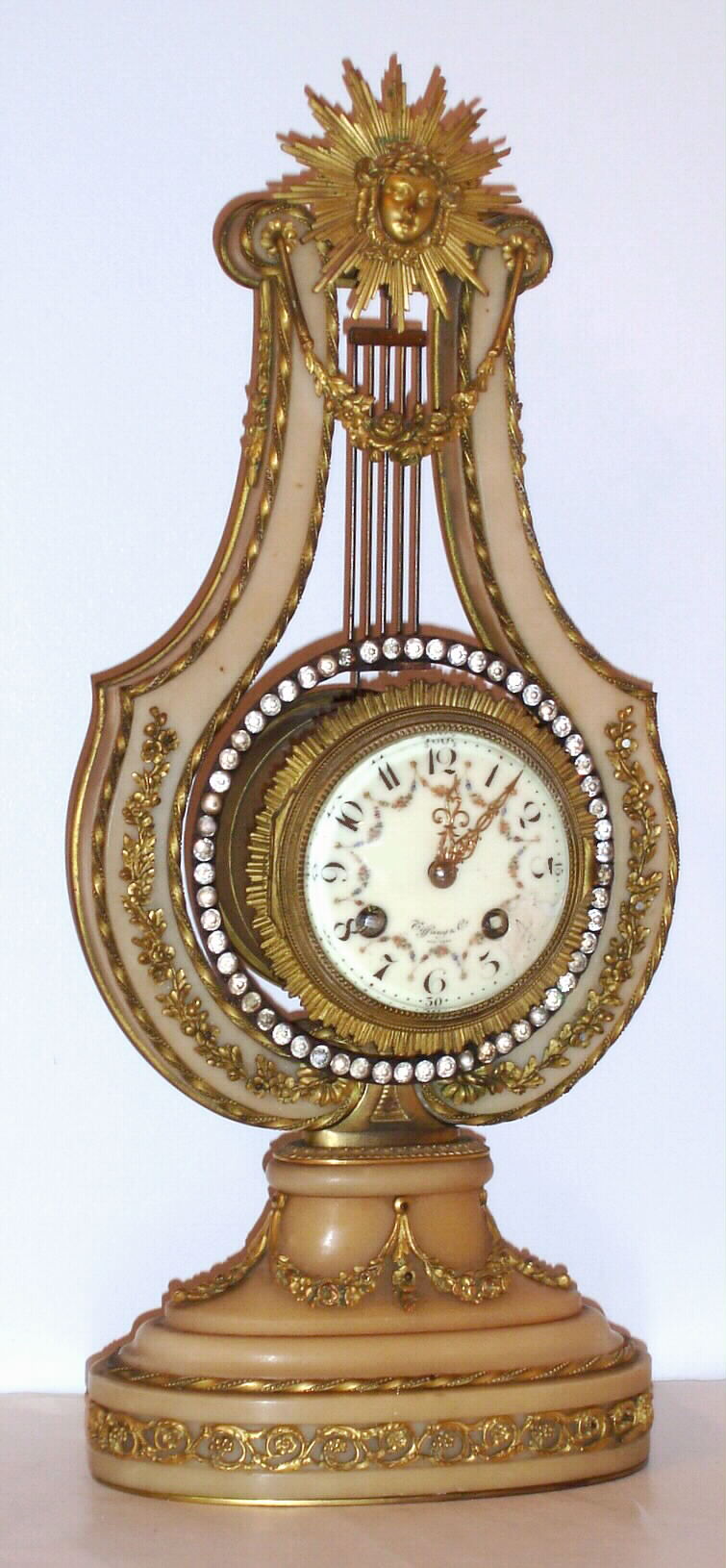 French lyre form mantel clock made for Tiffany and Co. New York (signed on movement and dial) with 8 day time and bell strike, spring driven movement in creamy onyx and ormolu case, c1890 — Antique Clocks Price Guide
