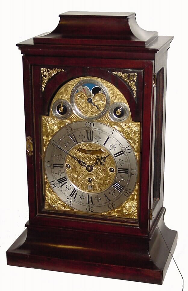 M. Bentwe, in Wien, Austrian bracket clock with calendar and moon phase 56 hour time and quarter strike crown verge movement in hard wood case with silvered chapter ring and unusual north wind brass spandrels and mock pendulum aperture, c1750, chain fusee for time train, backplate engraved in the English manner. — Antique Clocks Price Guide