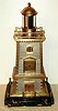 French, Lighthouse Clock with helical Torsion Pendulum, in a rectangular case simulating stone construction silvered center stones and brass-gilt corner stones. The square movement is signed with Guilmet trademark, serial No. 1023. The briskly rotating pendulum, suspended from the center of the dome, is surmounted by clear and colored prisms that simulate the motion of a lighthouse beacon. c.1885