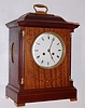 French mantel clock 8 day time and strike spring driven movement stamped "H and H MADE IN FRANCE" in mahogany case with satin wood inlay, fluted quarter columns with brass capitals and brass feet with porcelain dial and beveled glass, c1910