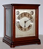 German, Winterhalder and Hofmeier, 8-day time and quarter striking on two gongs (bim-bam), wood and glass mantel clock retailed by Bailey, Banks and Biddle, Philadelphia.