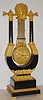 French, lyre form mantel clock, ebonized wood case with ormolu mountings, the pinwheel movement contained within the base of the gird iron pendulum, which has knife edge suspension, the entire movement and pendulum swinging as a single unit. Gilt engine turned dial with painted roman numerals and seconds hand, C. 1840