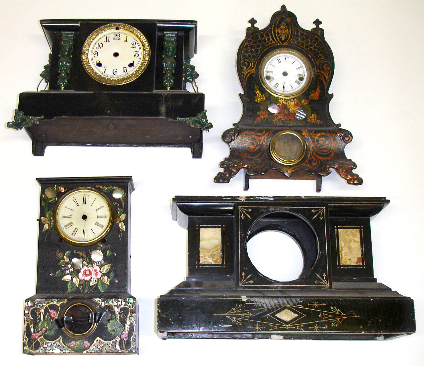 Four decorated black clock cases. 3 with dials. 2 iron fronts with lavish MOP inlay. 1 iron with cast feet and lion head handles. 1 French marble. Tallest is 16" high. — Antique Clocks Price Guide