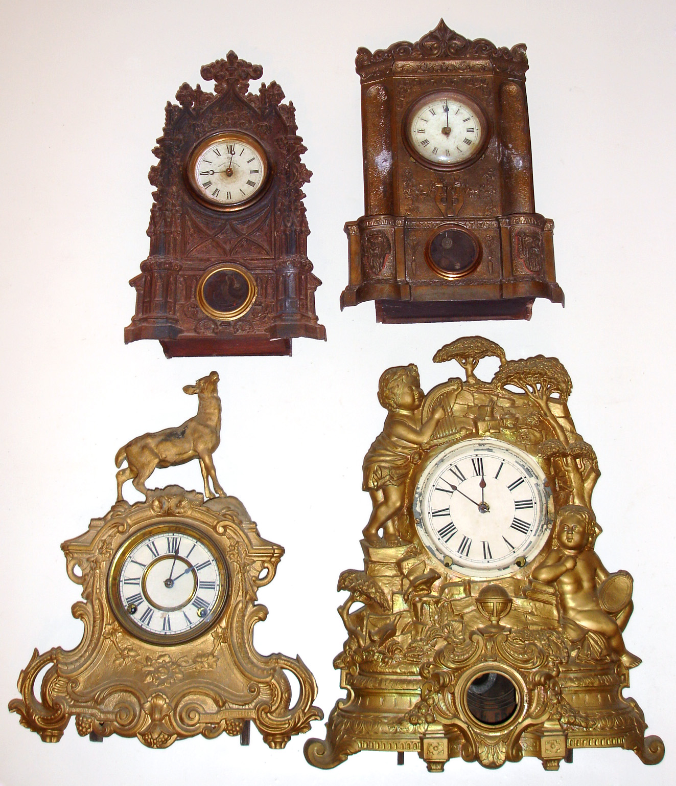 Four 8-day American iron fronts 2 gold figurals, 1 with U.S. Clock Co. dial in N. Muller No. 21 case. Largest is 20" high. — Antique Clocks Price Guide