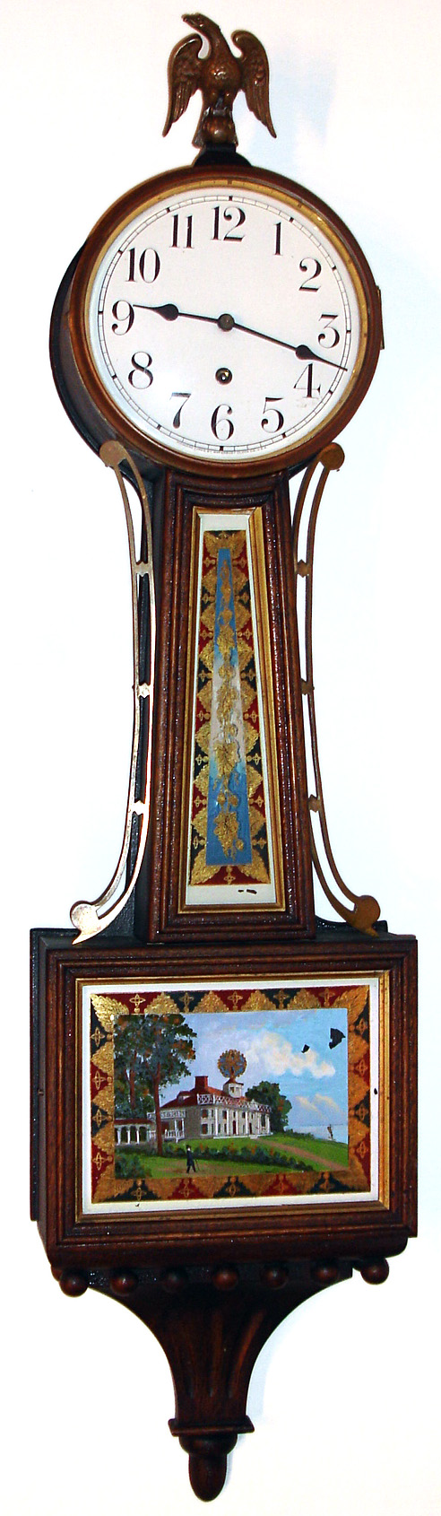 Waterbury Clock Co., Waterbury, Conn., "Willard No. 5" banjo wall clock 8 day time only weight driven movement in mahogany case with gilt molding around throat and lower tablets and porcelain enamel dial and cast brass bezel, c1906 — Antique Clocks Price Guide