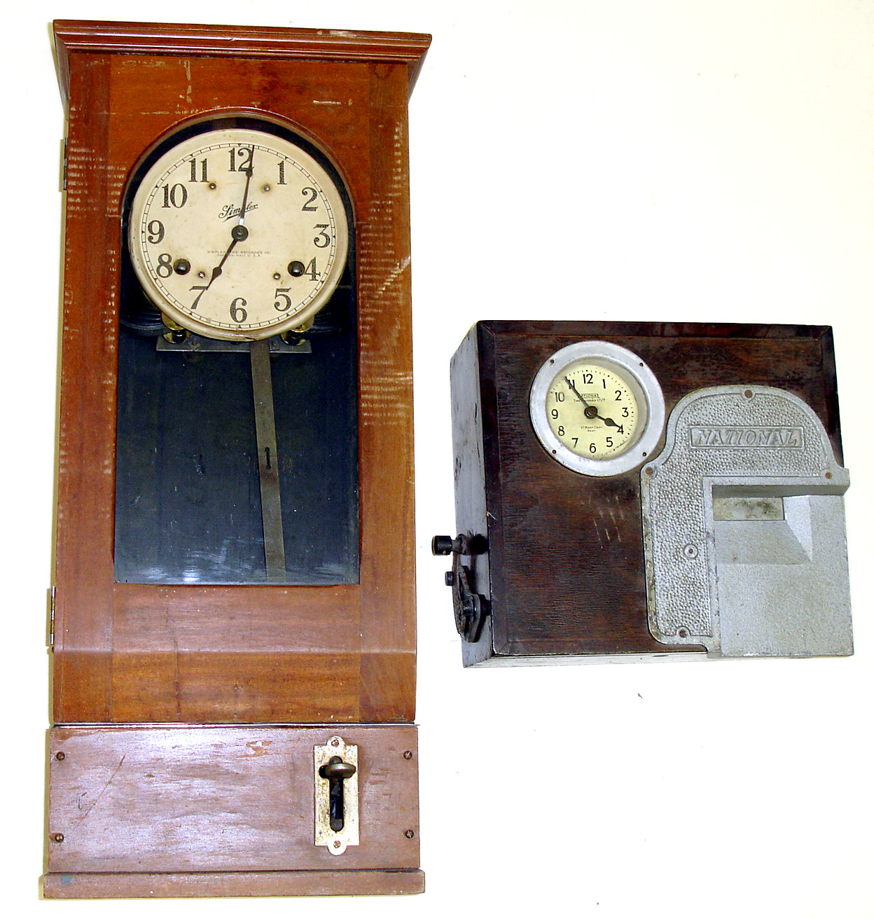 Two time recording 8 day clocks. First is Simplex, Gardner, Mass., U.S.A., 31" tall. Second is rarer, smaller (but also very heavy) English model, National Time Recorder Co., St. Mary Cray, Kent., 13" tall. — Antique Clocks Price Guide
