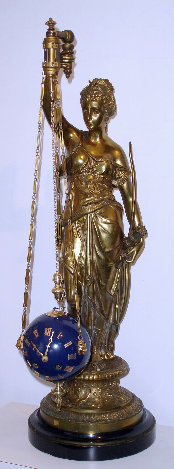French, bronze figure of Diana with bow, from which is suspended via three chains, a ball containing the movement, which travels in a circular / conical pattern motion when running, striking on bell, c1885 — Antique Clocks Price Guide