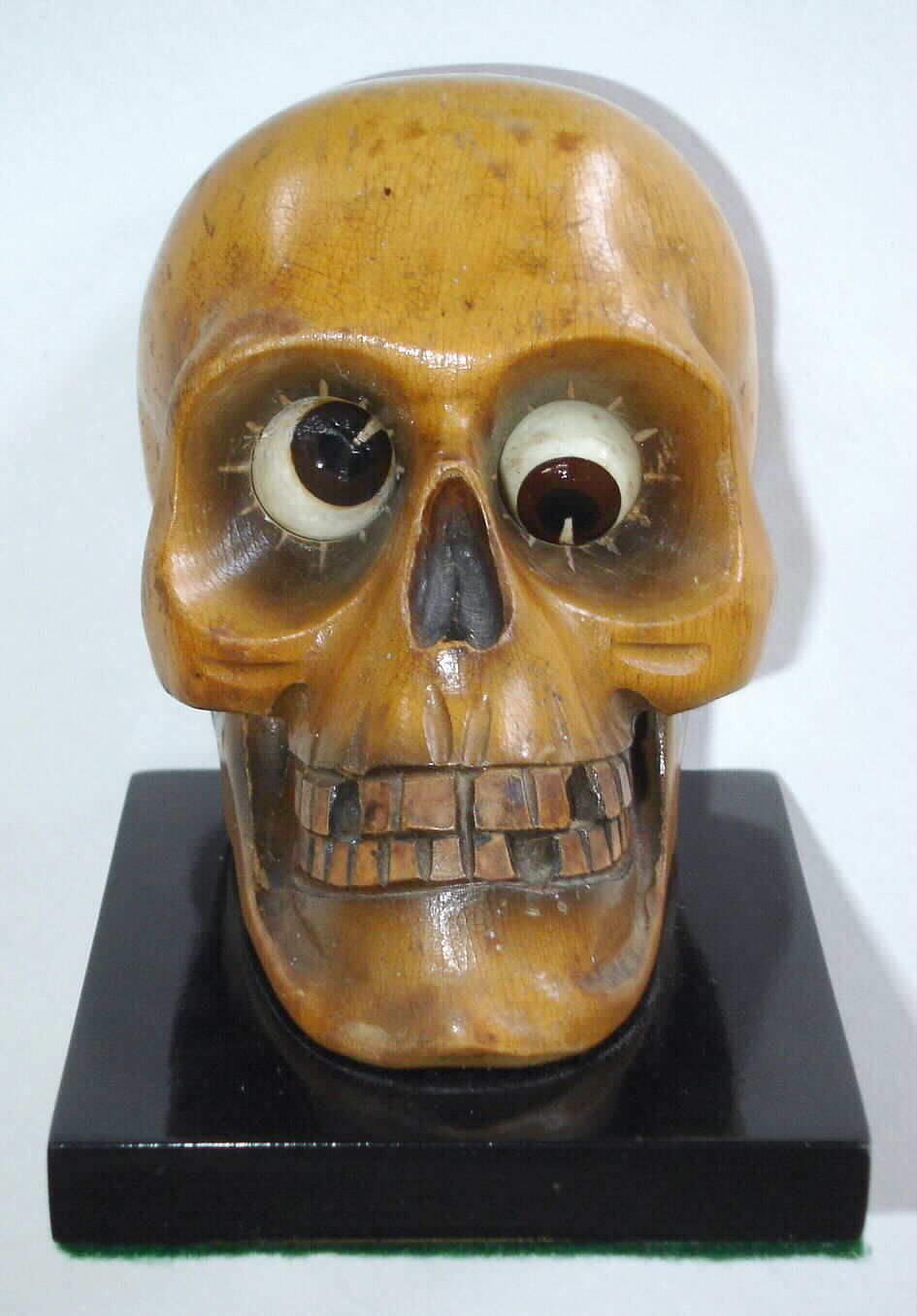 German, Oswald Uhrenfabrik, "Skull" of carved wood, telling time with rotating eyes; time in photo is 1:30; minutes showing to the right, c1935 — Antique Clocks Price Guide