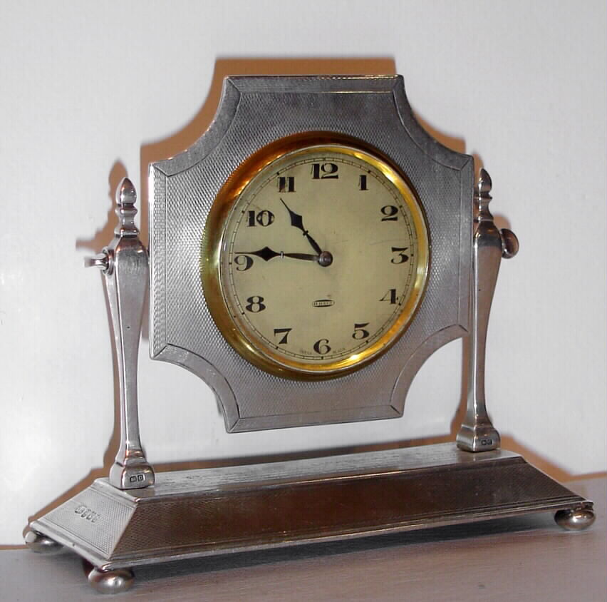 Swiss, 8 day sterling silver lever movement desk timepiece. c. 1928 This was a presentation piece, engraved on the base and reads as follows: "Queen Victoria Nursing Inst New Malden, Presented to Mrs. Bevan by the Ladies Committee as token of esteem and in recognition of her valued services as Lady President from 1897 to 1928." — Antique Clocks Price Guide